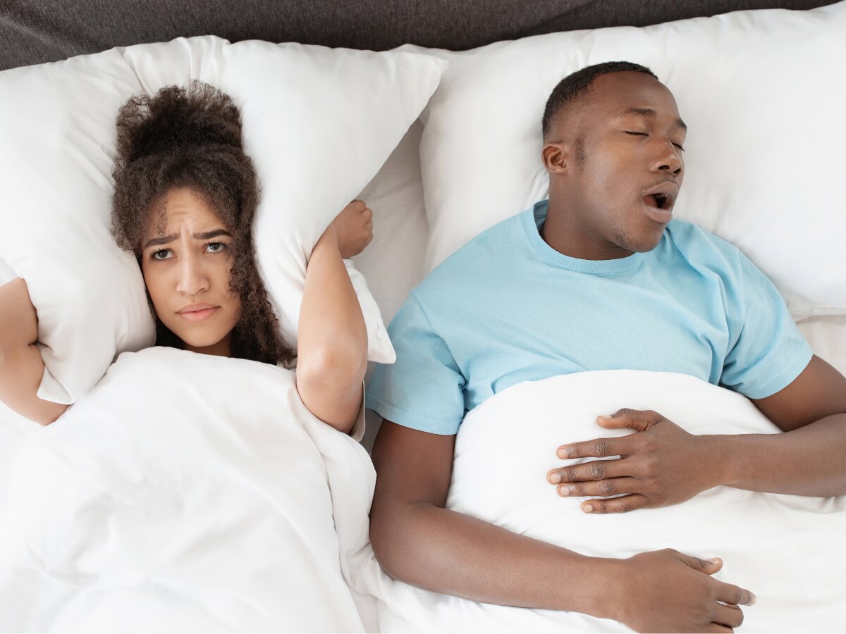 Pessoa incomodada com o ronco de quem dorme ao lado